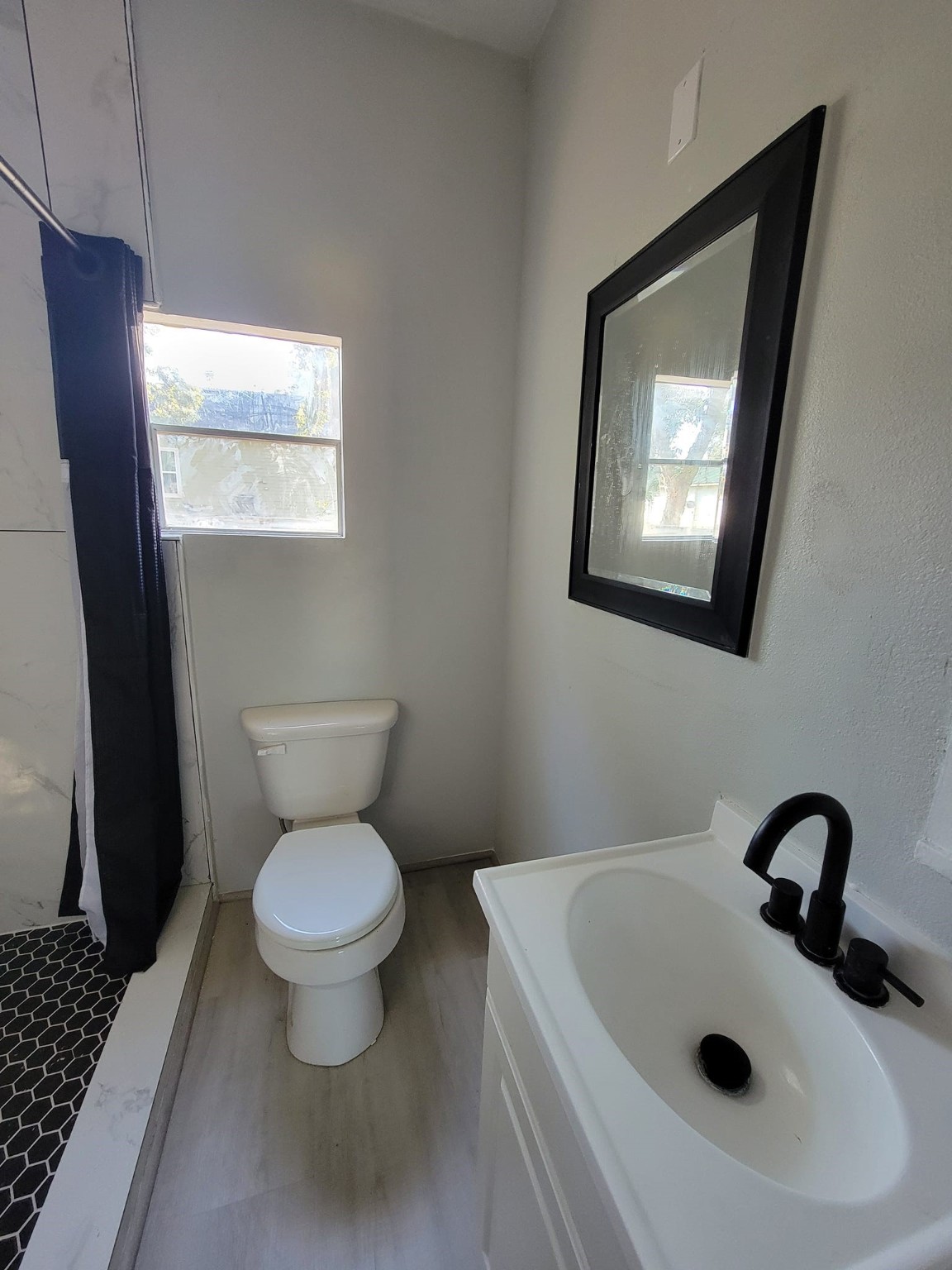 801 Willcox Street Anahuac, TX 77514 - Photo 8 of 10 a bathroom with a toilet sink and mirror