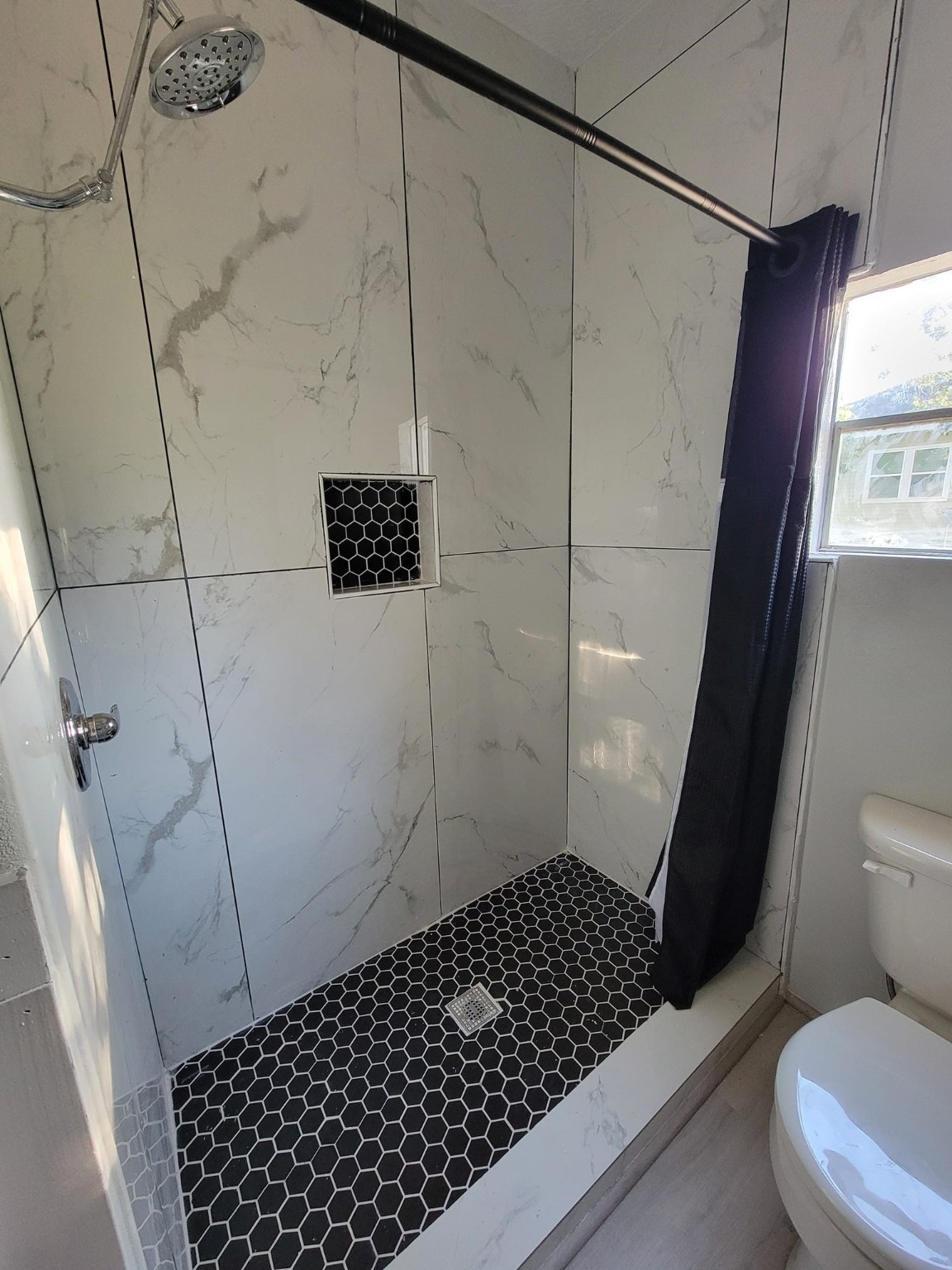 801 Willcox Street Anahuac, TX 77514 - Photo 9 of 10 a bathroom with a sink a toilet a window and shower