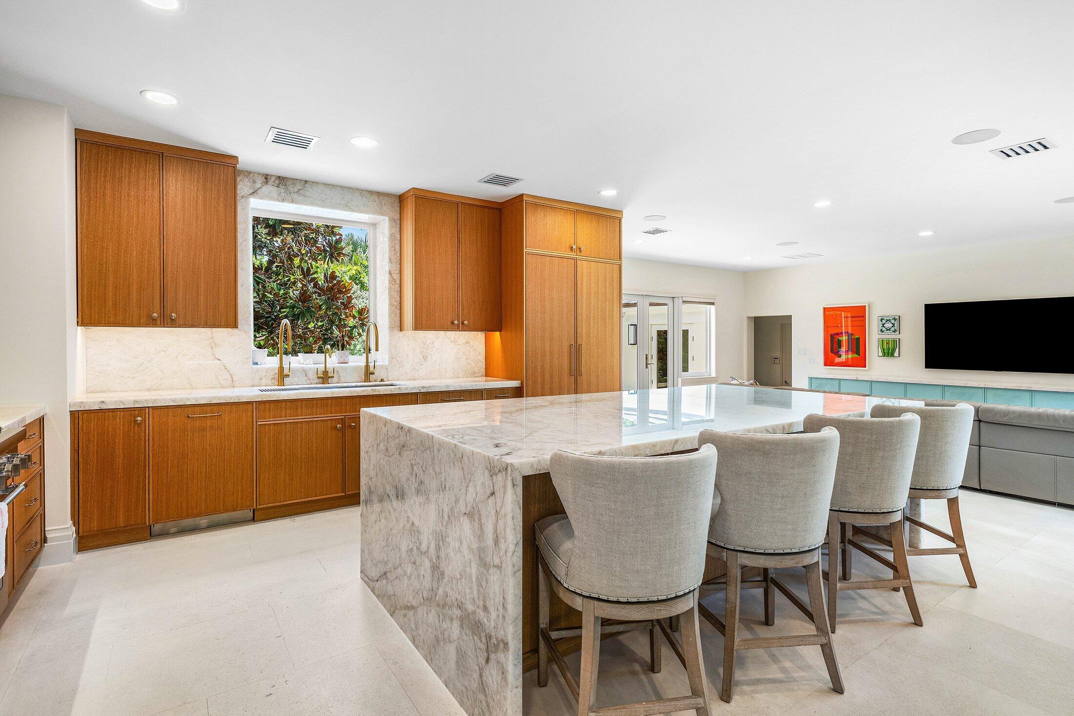 5 Osprey Court Ocean Ridge, FL 33435 - Photo 15 of 39 a kitchen with kitchen island a dining table chairs and white cabinets