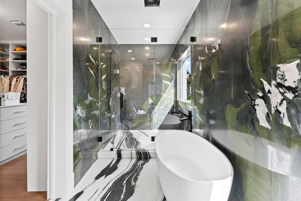 5 Osprey Court Ocean Ridge, FL 33435 - Photo 29 of 39 a bathroom with a mirror a sink and glass door