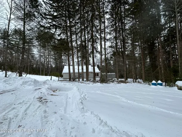 a street view of a house with a snow on the road