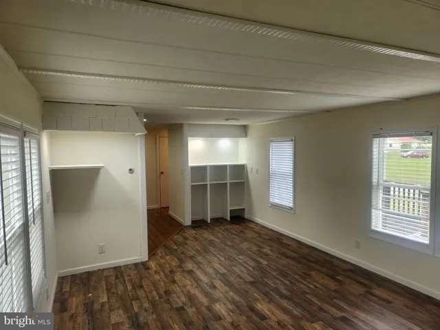an empty room with windows and cabinet