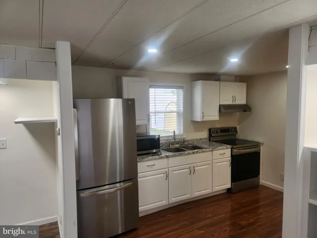 a kitchen with a refrigerator sink and cabinets