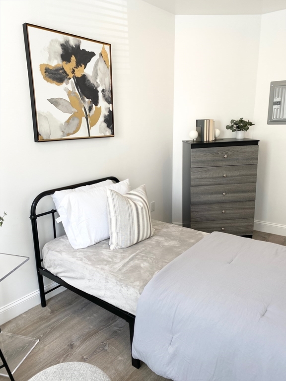 69 North Common Street, Unit 3 Lynn, MA 01902 - Photo 1 of 15 a bedroom with a bed and painting on the wall