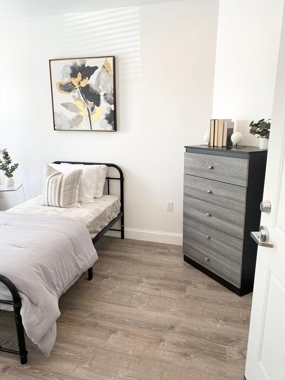 69 North Common Street, Unit 3 Lynn, MA 01902 - Photo 2 of 15 a bedroom with a bed and a cabinet