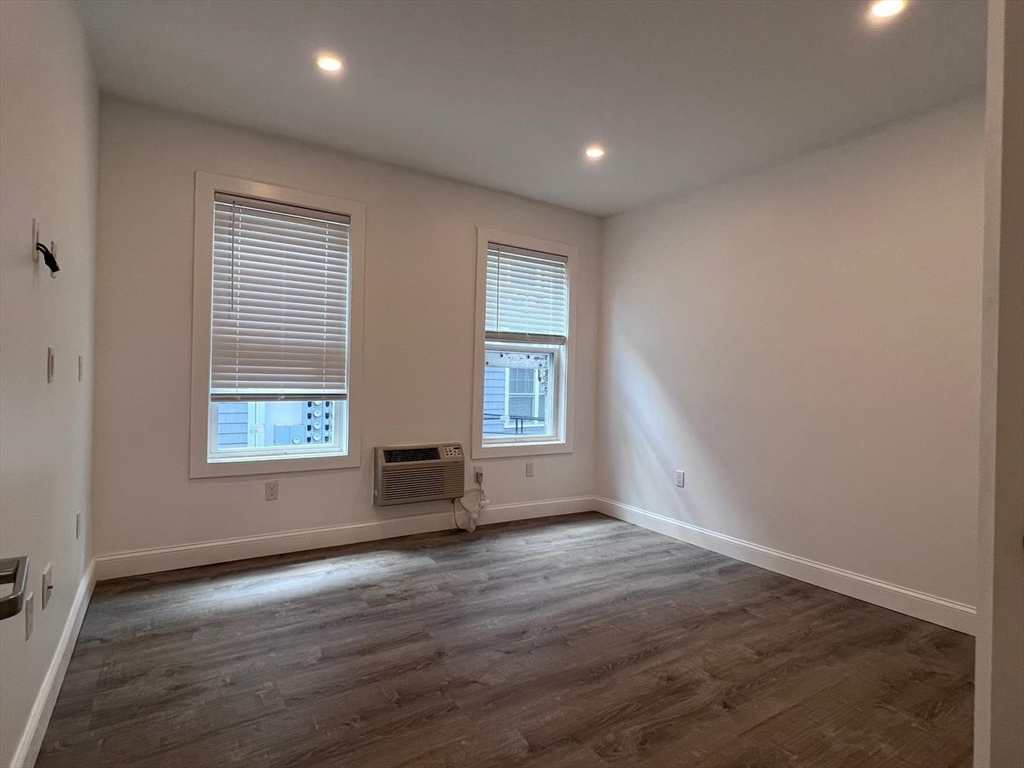 69 North Common Street, Unit 3 Lynn, MA 01902 - Photo 7 of 15 an empty room with wooden floor and windows