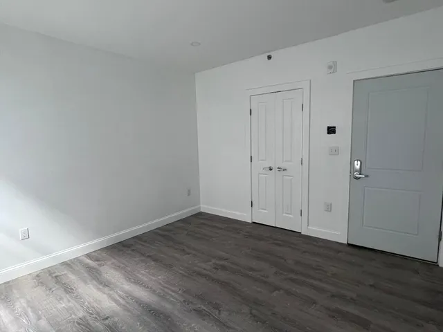 a view of an empty room with wooden floor