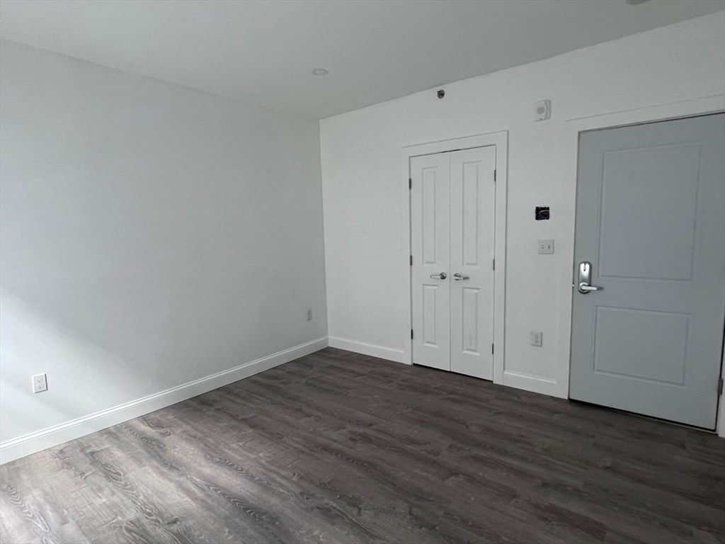 69 North Common Street, Unit 3 Lynn, MA 01902 - Photo 8 of 15 a view of an empty room with wooden floor