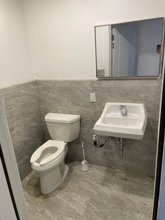 69 North Common Street, Unit 3 Lynn, MA 01902 - Photo 9 of 15 a bathroom with a sink a toilet and mirror