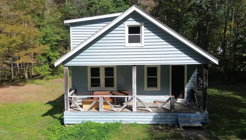 a view of house with backyard and outdoor seating
