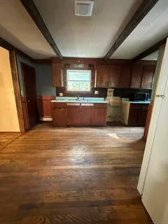 a room with stainless steel appliances kitchen island granite countertop a refrigerator and a stove top oven