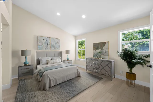 a bedroom with a large bed and a potted plant