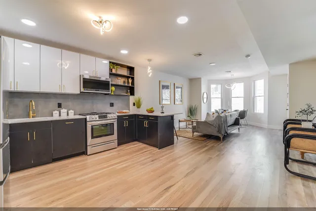 a kitchen with stainless steel appliances granite countertop a refrigerator and a stove top oven