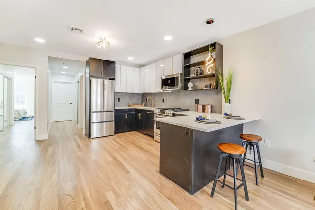 a large kitchen with stainless steel appliances and a stove top oven
