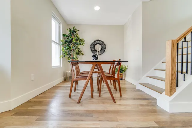 a view of a hallway with wooden floor furniture and a potted plant