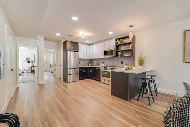a living room with furniture and kitchen view