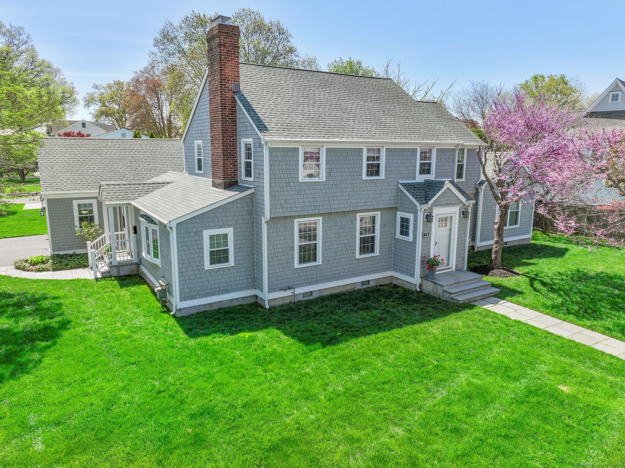 a aerial view of a house next to a big yard and large trees