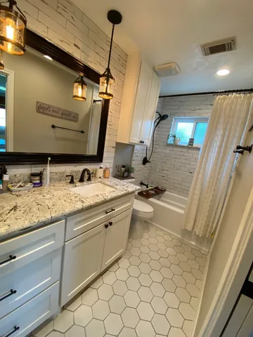 a bathroom with a sink a toilet and mirror