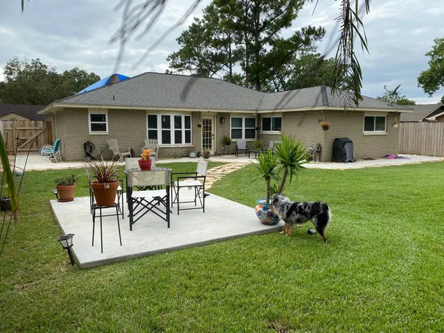 a view of a house with a backyard and a patio