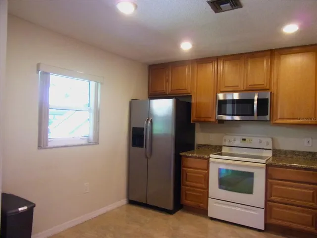 a kitchen with stainless steel appliances a stove a microwave and a refrigerator