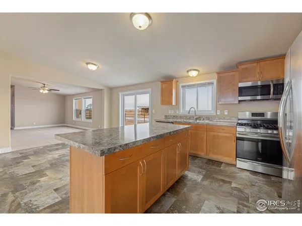 a kitchen with stainless steel appliances granite countertop a stove a sink and a refrigerator