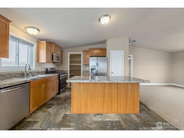 a kitchen with stainless steel appliances granite countertop a sink a stove top oven a counter space and cabinets