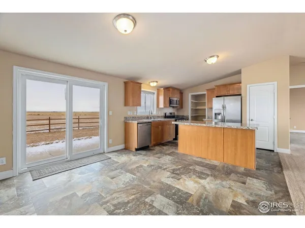 a large kitchen with cabinets and a wooden floor
