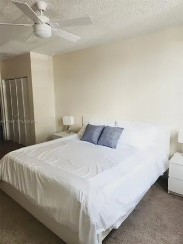 a bedroom with a bed and a ceiling fan