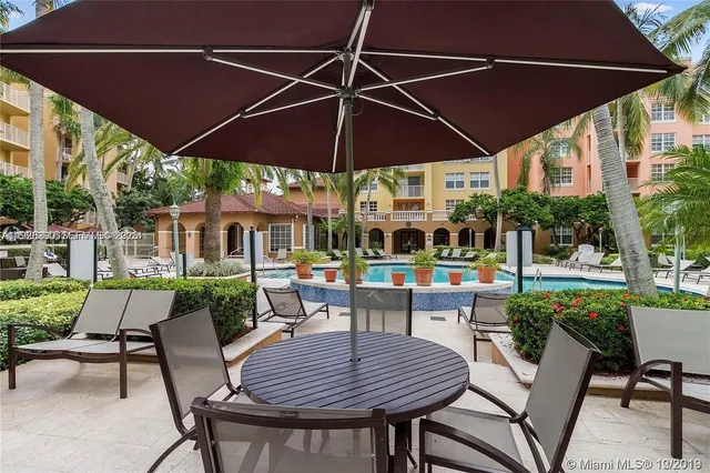a patio with a table and chairs under an umbrella