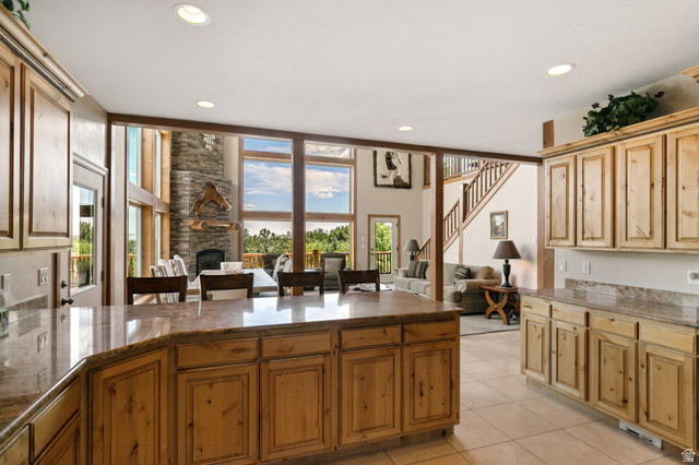755 South Zion Ridge Drive Orderville, UT 84758 - Photo 84 of 84 Kitchen with dark stone countertops, a kitchen breakfast bar, open floor plan, a fireplace, and light tile patterned floors