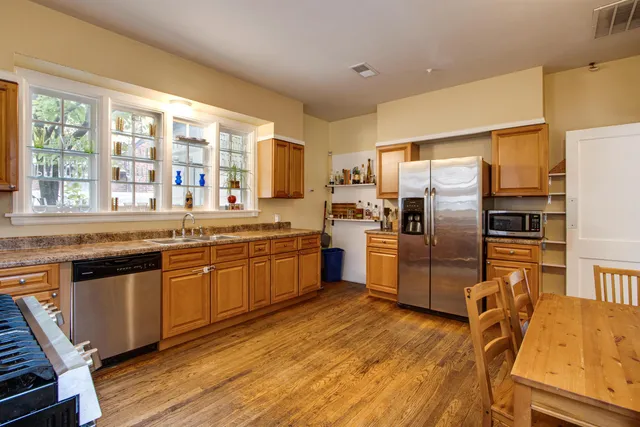 a kitchen with stainless steel appliances granite countertop a refrigerator a sink a stove and island