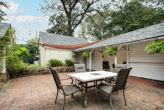 a view of patio with table and chairs and potted plants