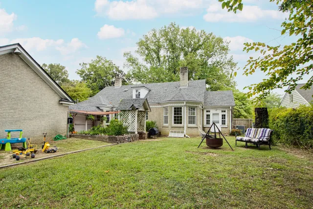 a front view of a house with a garden and trees