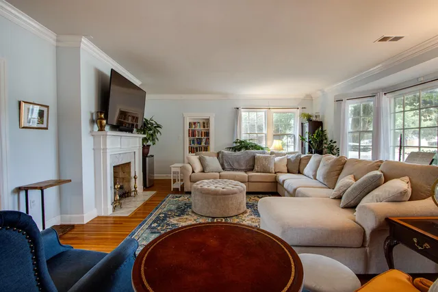 a living room with furniture a flat screen tv and a fireplace