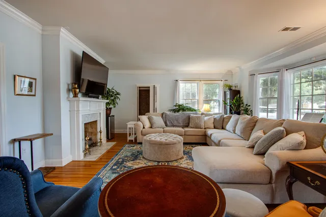 a living room with furniture a flat screen tv and a fireplace