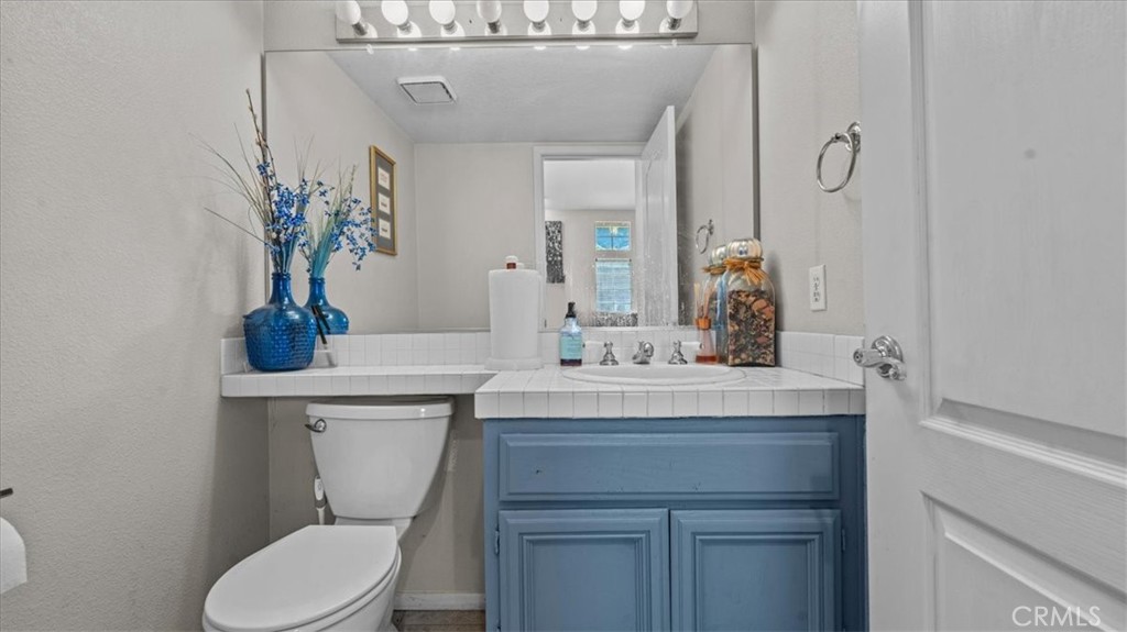 1671 Dominguez Ranch Road Corona, CA 92878 - Photo 23 of 42 A conveniently located half bath with a vanity and mirror, ideal for guests.
