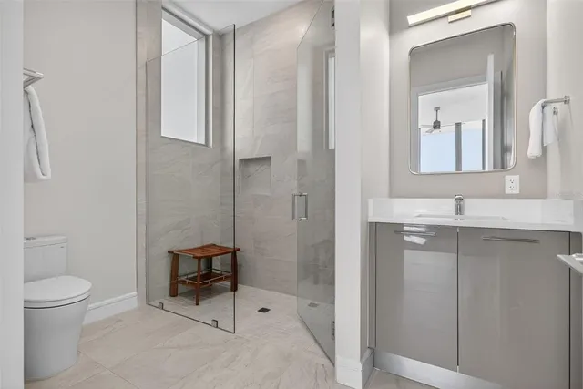 a bedroom with a bed and large windows