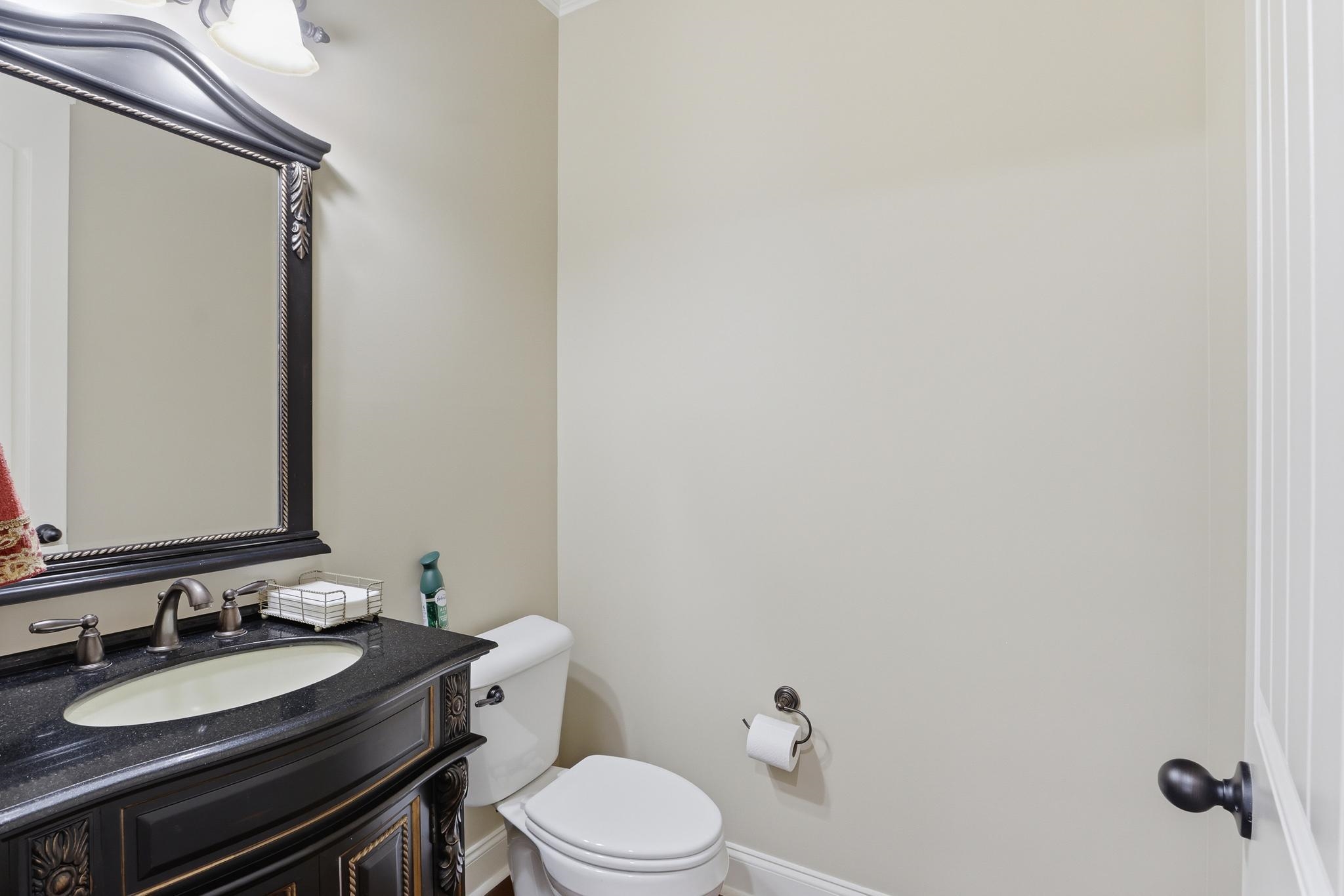 1301 Conser Street Collierville, TN 38017 - Photo 19 of 40 a bathroom with a granite countertop toilet sink and mirror