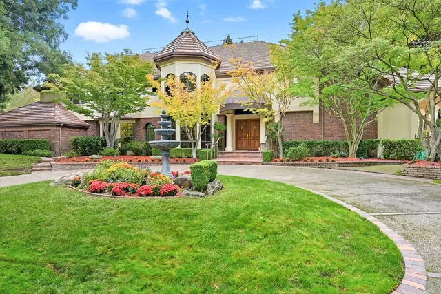 a front view of a house with a big yard and potted plants