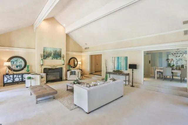 a living room with furniture a clock and a fireplace