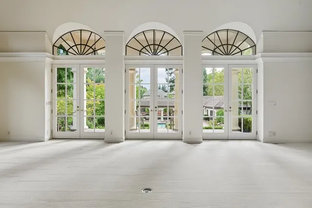 a view of an empty room with chandelier and a fireplace