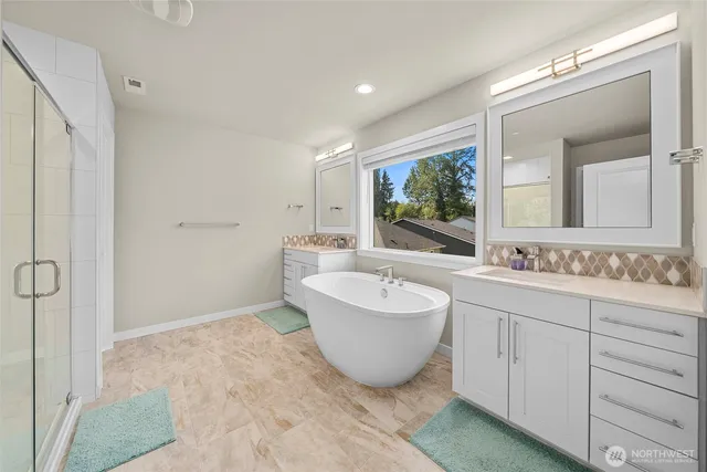 a spacious bathroom with a double vanity sink a mirror and a bathtub