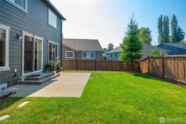 a view of a house with backyard and a tree