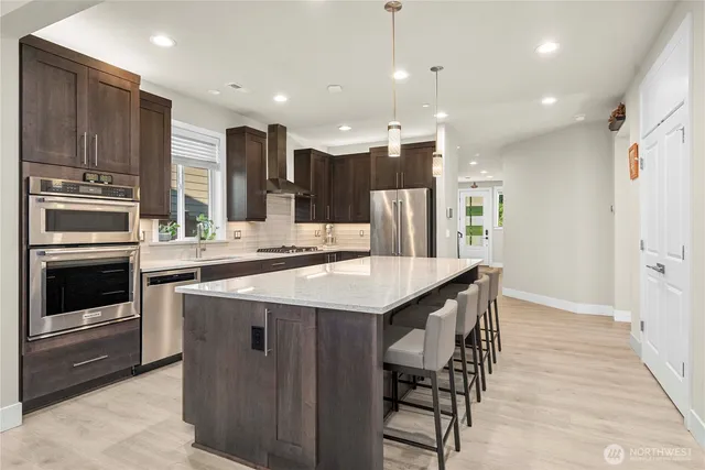 a kitchen with stainless steel appliances kitchen island granite countertop a kitchen island a stove and a sink