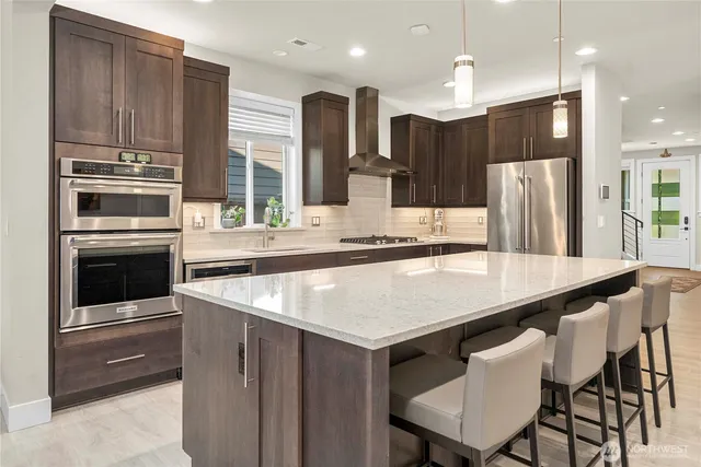 a kitchen with kitchen island wooden cabinets and stainless steel appliances