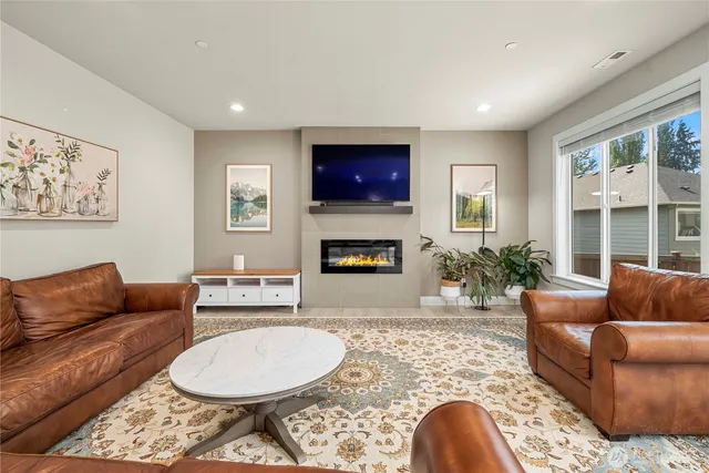 a living room with furniture a flat screen tv and a fireplace