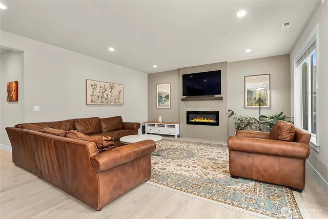 a living room with furniture a flat screen tv and a fireplace