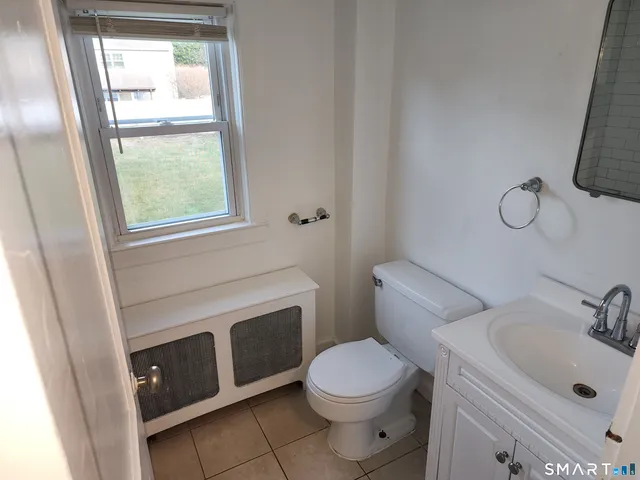 a bathroom with a toilet sink vanity and mirror