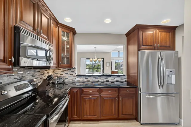 a kitchen with stainless steel appliances wooden cabinets and a stove top oven