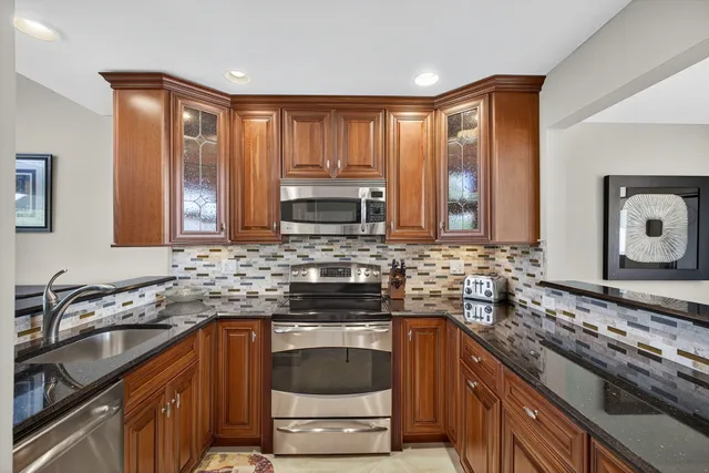 a kitchen with stainless steel appliances wooden cabinets and a stove top oven